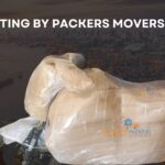 Fully packed Indian motorbike by packers and movers using cargo, bubble wrap, and lamination for safe transportation. The bike is securely wrapped in protective materials ensuring its safety during the move."